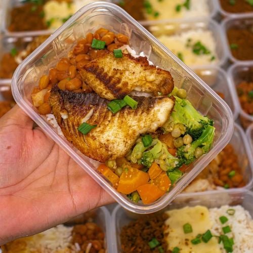 Grilled fish with roasted vegetables and broccoli in meal prep container