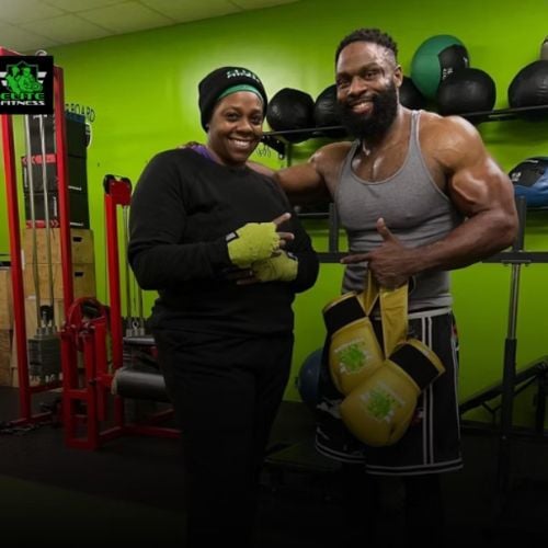 Two fitness enthusiasts smiling in gym with boxing gloves and equipment