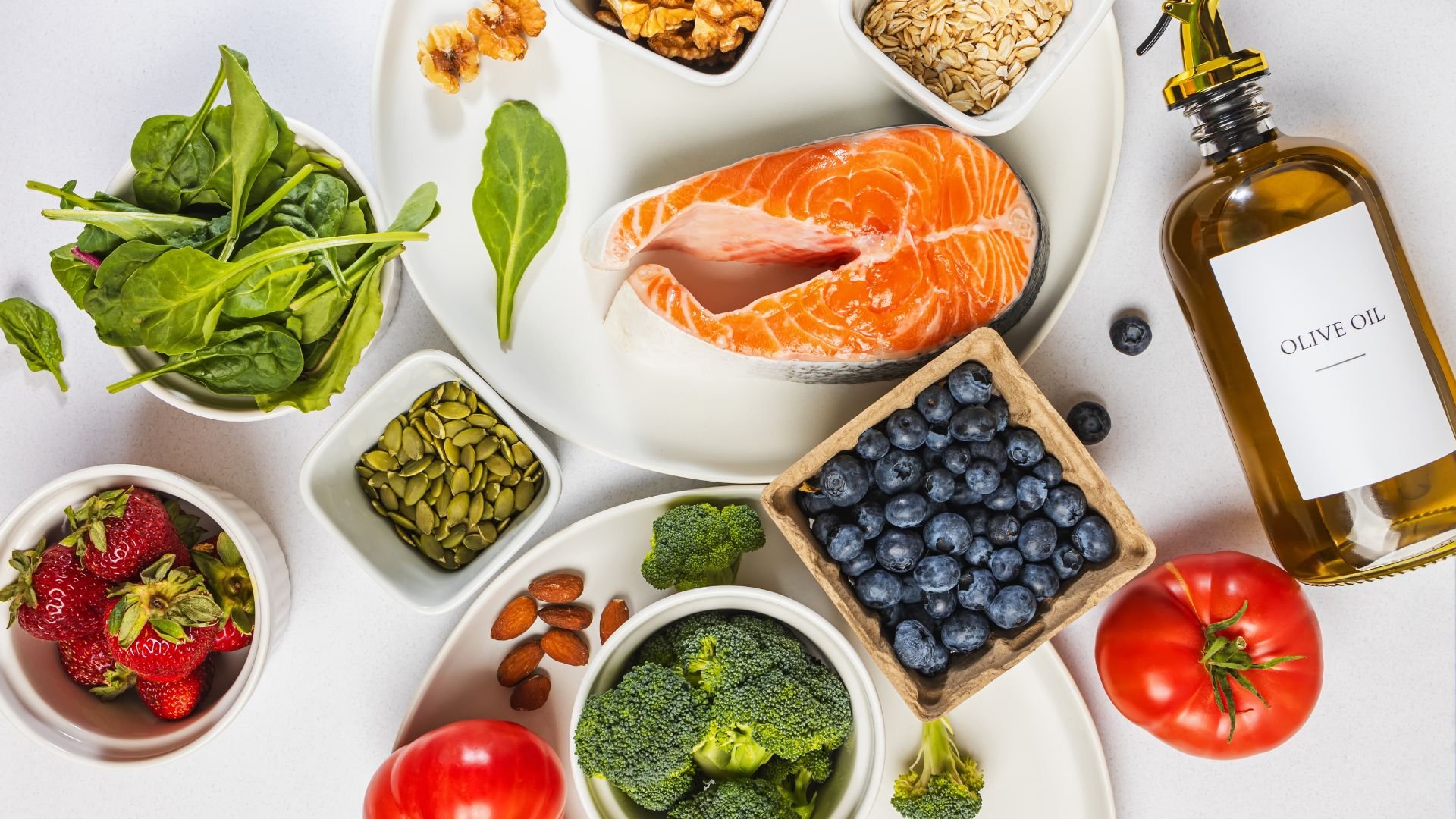 Healthy ingredients including salmon, vegetables, fruits, nuts, and olive oil